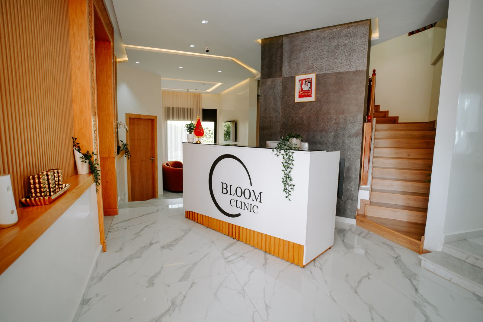 Accueil de Bloom Clinic, comptoir blanc au logo de la clinique, sol de marbre et boiseries claires